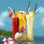 three fresh juices and coconut on the beach on the table